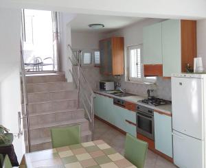 a kitchen with a staircase and a table and chairs at Holiday home Penić in Rogoznica