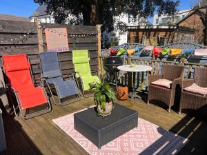 a group of colorful chairs and a table on a deck at The Boho - 4 min walk to beach & town in Bournemouth