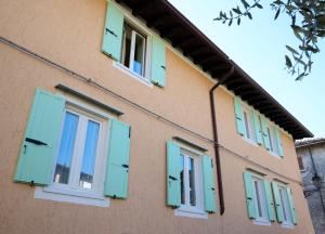 a building with green shutters on it at Dolce Lago B&B in San Felice del Benaco