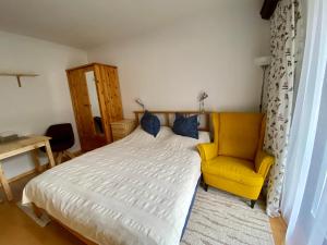 a bedroom with a bed and a yellow chair at Studio Apartment BKK in Bad Kleinkirchheim