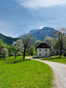 a dirt road leading to a house with mountains in the background at Apartments Mala Korita Soče in Soča