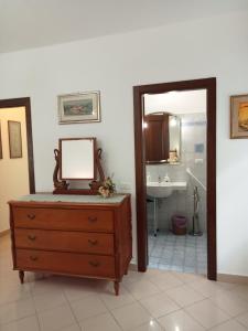 a bathroom with a dresser with a mirror and a sink at A CASA DI MATTEO in Brugnato
