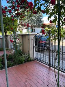 ein schwarzes Eisentor mit roten Rosen drauf in der Unterkunft Casa vacanza in Cecina