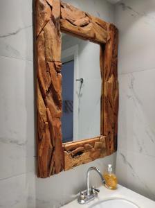uma casa de banho com um espelho de madeira sobre um lavatório em Paradise Pirgaki Naxos em Agiassos