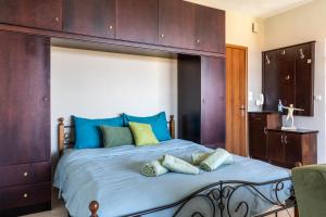 1 dormitorio con 1 cama grande con almohadas azules y verdes en Mar y Montaña Apartments Litochoro, en Litóchoron