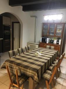 a dining room table with chairs and a kitchen at Vadászház in Rádócújfalu