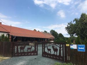 a gate with a fence with drawings of giraffes on it at Vadászház in Rádócújfalu +7 photos