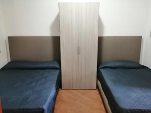 a bedroom with two beds and a cabinet at B&B Azzurro in Agropoli