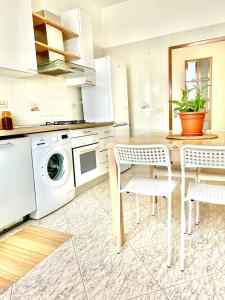 レッジョ・エミリアにあるSM Hospitality LAGHIのキッチン(テーブル、椅子、洗濯機付)