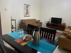 a dining room with a table with a vase on it at Ahva I Residence in Jinja