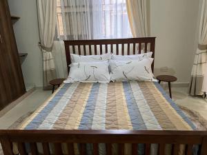 uma cama grande com uma estrutura de madeira num quarto em Ahva I Residence em Jinja