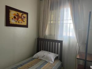 Habitación pequeña con cama y ventana en Ahva I Residence en Jinja