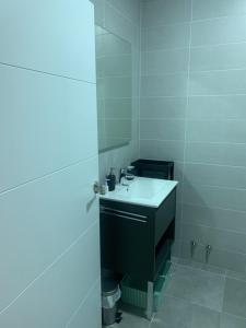 a white bathroom with a sink and a mirror at Apartamentos Cañamal in Llanes