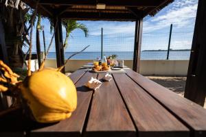 a picnic table on the beach with a view of the ocean at Les Villas 33 Bis in Baie du Tombeau