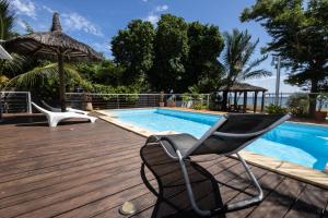 a chair sitting on a deck next to a swimming pool at Les Villas 33 Bis in Baie du Tombeau
