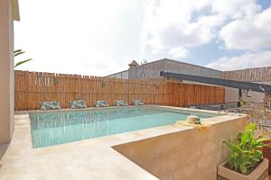 una piscina en un patio trasero con una valla de madera en Riad Amya & Spa en Marrakech