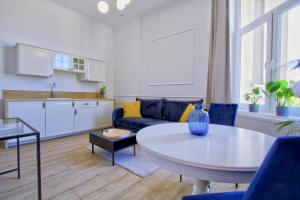 un salon avec un canapé et une table et une cuisine dans l'établissement Ottimo Apartamenty Jagiellońska, à Bydgoszcz