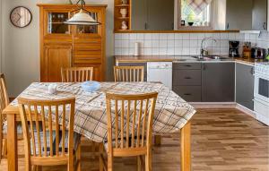 KvänarpにあるBeautiful home in Vittaryd with 3 Bedrooms and WiFiのキッチン(テーブル、椅子付)