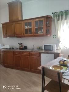 a kitchen with wooden cabinets and a table with a bowl of fruit at Casa do Trovão - Douro in Peso da Régua +35 photos