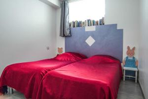 ein Schlafzimmer mit einem roten Bett mit einer roten Decke in der Unterkunft Appartement avec jardin intérieur 4 pers centre ville in Nemours