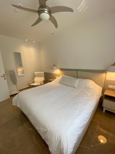 um quarto com uma grande cama branca e uma ventoinha de tecto em Theta Θ2 Luxury Apartment's em Tessalônica