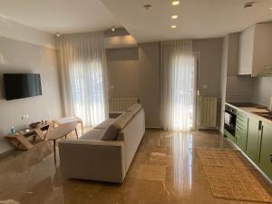 un ampio soggiorno con divano e cucina di Theta Θ2 Luxury Apartment's a Salonicco