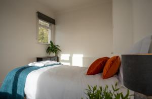 NorburyにあるEntire home in Streatham with lovely views & ultra fast Wi-Fiのベッドルーム(オレンジ色の枕が付いた大きな白いベッド付)