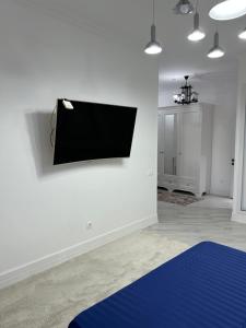 a room with a flat screen tv on a wall at Уютная квартира на набережной! in Astana