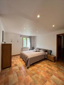 Un dormitorio con una cama y suelo de madera. en Villa Comorebi Provence, en Entrecasteaux