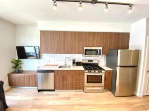 a kitchen with wooden cabinets and stainless steel appliances at Lovely Brand New Suite in Sidney