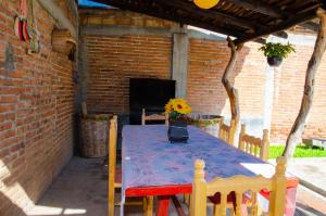 una mesa azul en un patio con una pared de ladrillo en Casa Blanca, Tlacolula, en Tlacolula de Matamoros