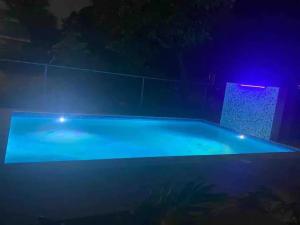 a large swimming pool with lights in the dark at The Exoria Cottage in Ocho Rios