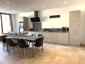 a kitchen with a table and chairs in a kitchen at Maison de village 150 M2 au calme climatisée, piscine in Rasteau