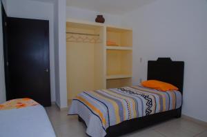 Dormitorio con cama con almohada naranja en Casa Blanca, Tlacolula, en Tlacolula de Matamoros