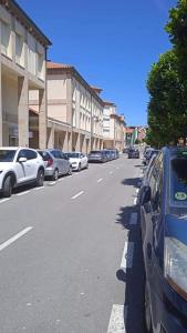 een rij auto's geparkeerd aan de kant van een straat bij Altamar in Llanes