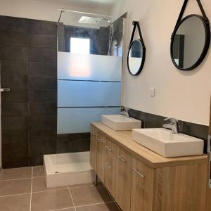 a bathroom with two sinks and two mirrors at Maison de village 150 M2 au calme climatisée, piscine in Rasteau