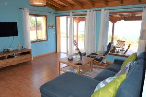 Una sala de estar con un sofá azul y una mesa. en Casa Florita, en Puntagorda