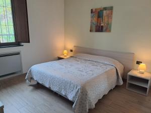 een slaapkamer met een bed en 2 tafels met lampen bij Agriturismo A' Taversa in Levanto
