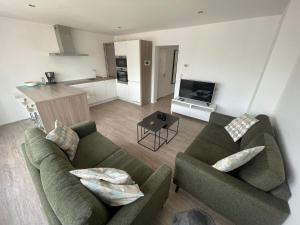 ミッデルケルケにあるCaroline Chérieのリビングルーム(ソファ2台付)、キッチンが備わります。