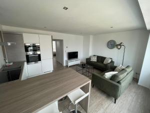 ミッデルケルケにあるCaroline Chérieのソファとテーブルのあるリビングルーム