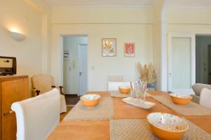 a dining room with a table with bowls on it at Gardenia Suite Corfu Town in Corfu