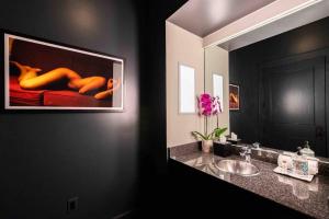 a bathroom with a sink and a picture of a woman on a couch at *New* Bourbon City Luxury Guest House in Louisville