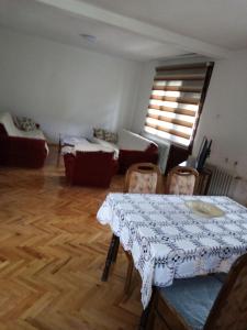 uma sala de estar com uma mesa e cadeiras e um sofá em Kecman em Drvar