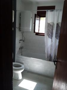 a bathroom with a tub and a toilet and a shower curtain at Kecman in Drvar