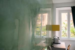 Catone Luxury Rooms في روما: غرفة مع نافذة ومكتب مع مصباح