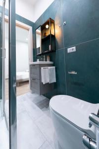 a bathroom with a white toilet and a green wall at Catone Luxury Rooms in Rome