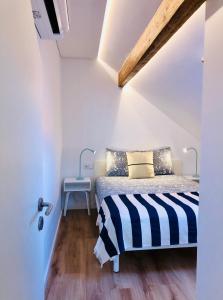 een slaapkamer met een bed met een zwart-wit gestreepte deken bij Matosinhos Beach Loft in Matosinhos