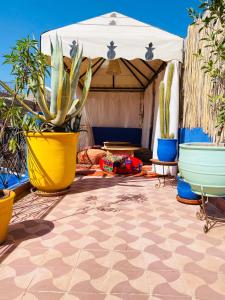 a patio with potted plants and an umbrella at RIAD GALIYA in Marrakech
