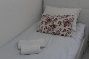 uma cama branca com uma almofada e uma toalha em Red Apartment em Sarajevo