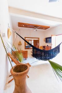 een woonkamer met een hangmat en een plant bij Casita con cama King, tina de baño, A/A y Netflix in Bacalar